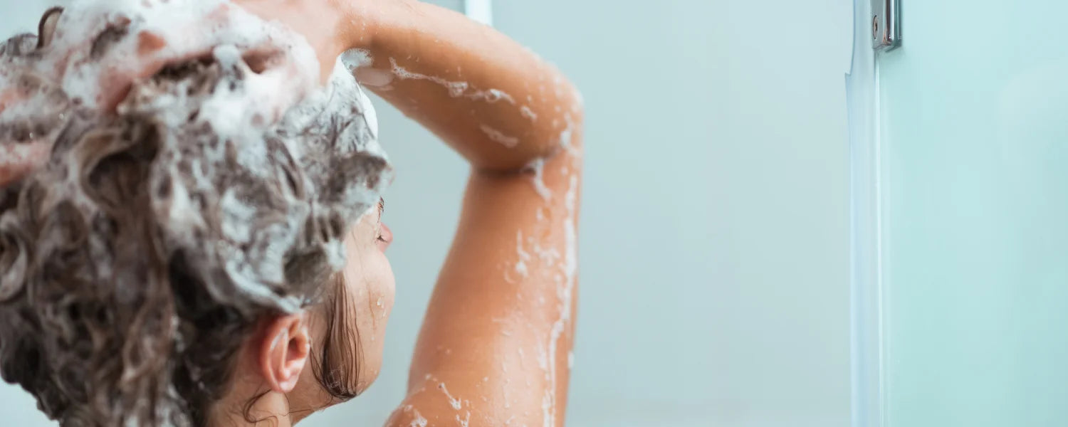 Kvinna använder volymschampo för sitt hår
