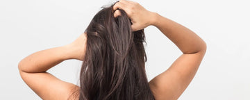 Kvinna med torr hårbotten skrapar
