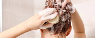 Kvinna tvätter hår i kallt vand