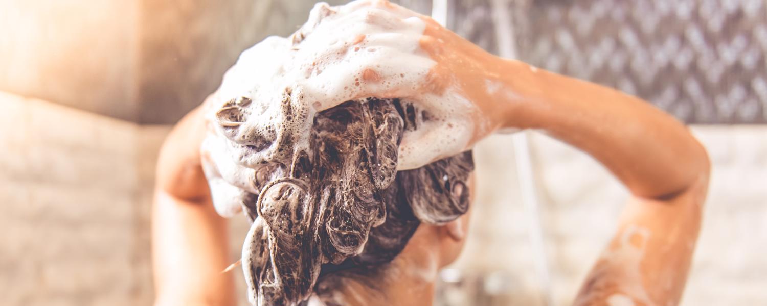 Tjej tvättar håret med schampo som motverkar håravfall