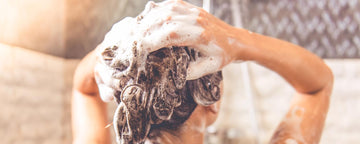 Tjej tvättar håret med schampo som motverkar håravfall