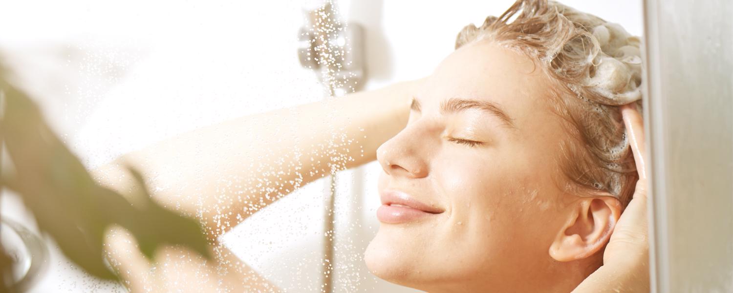 Flickan tvättar håret med sulfat- och silikonfritt schampo